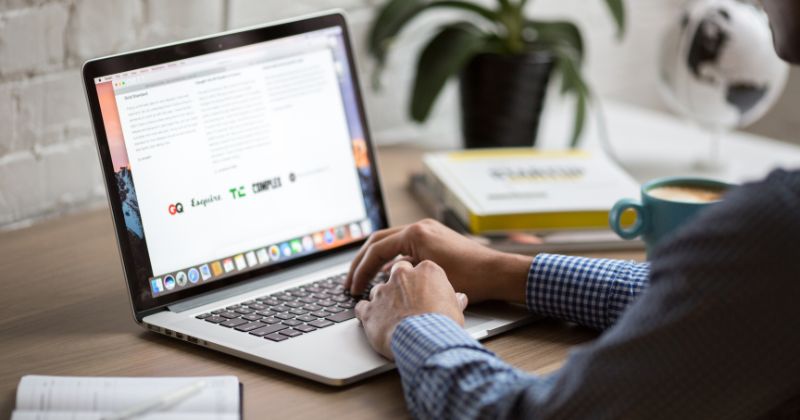 Person analysing a website and its content while enjoying a cup of coffee