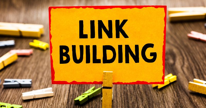 The word "link building" printed on a yellow paper square.